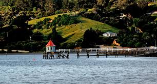 Bay with wharf against a green mountain background