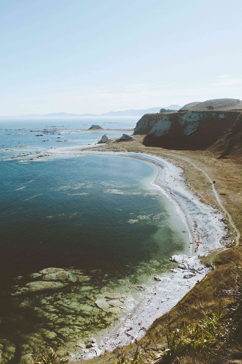 View of a long beach beside a cliff with a clear horizon at Kaikoura, New Zealand