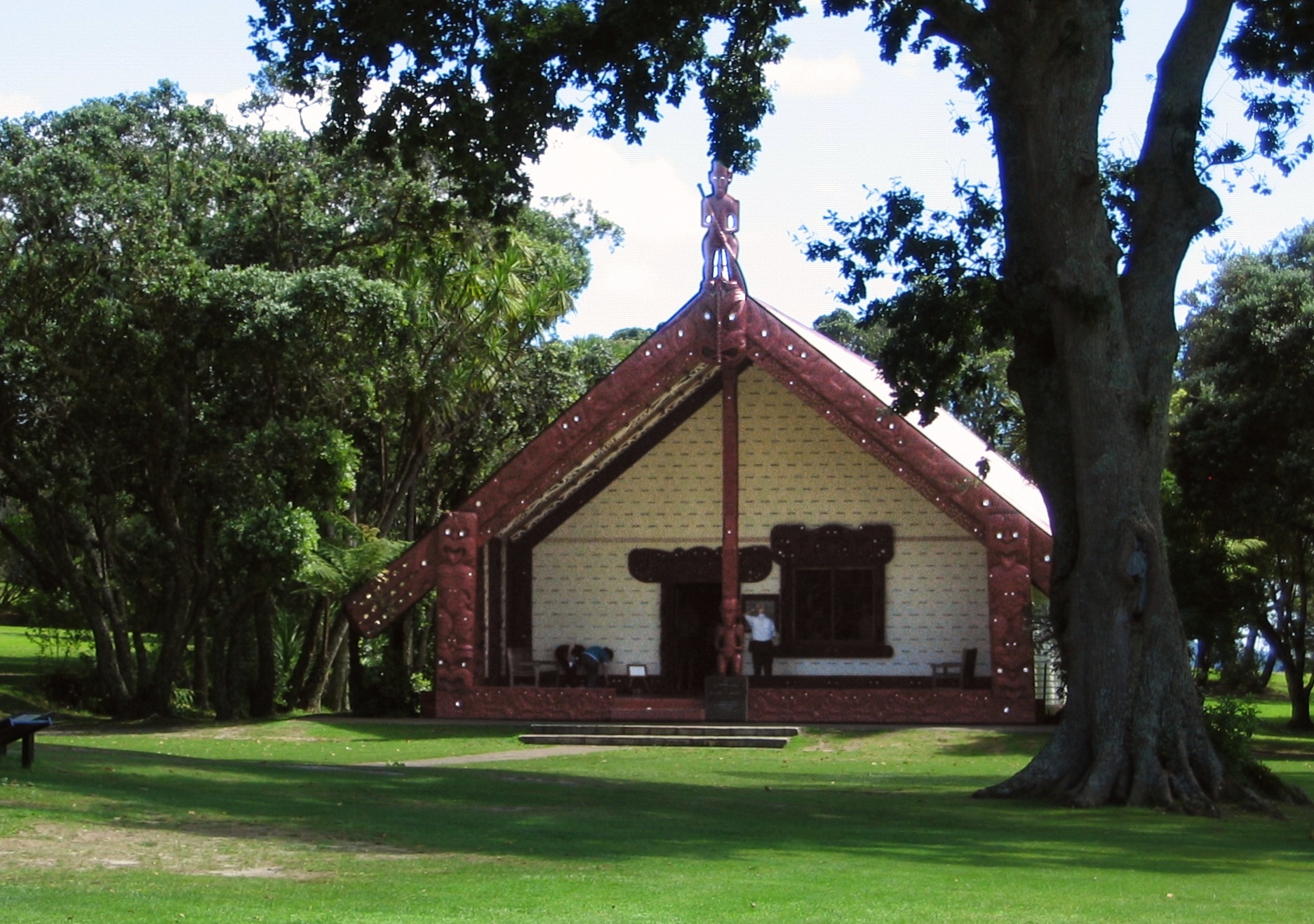 Building with a carved pillar under a tree, Waitangi Treaty Grounds, New Zealand