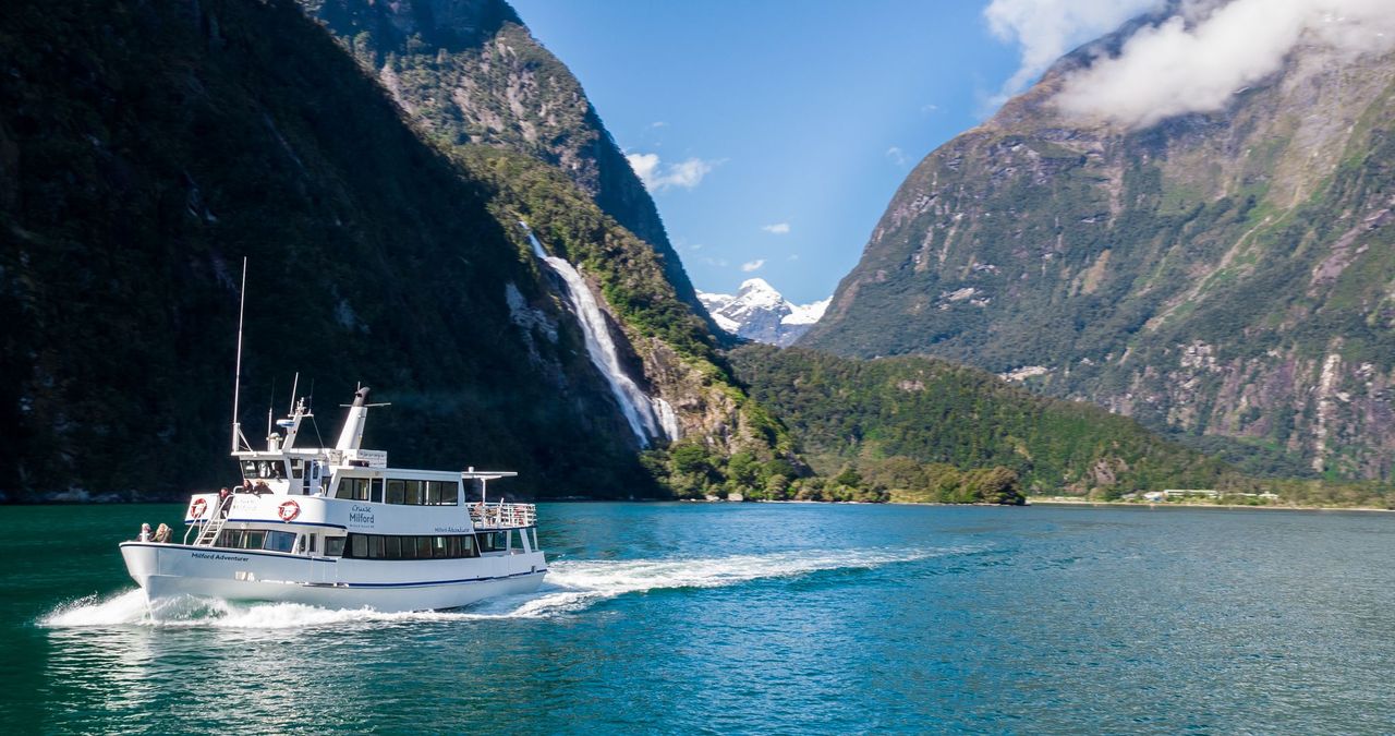 A boat sailing on a lake between mountains