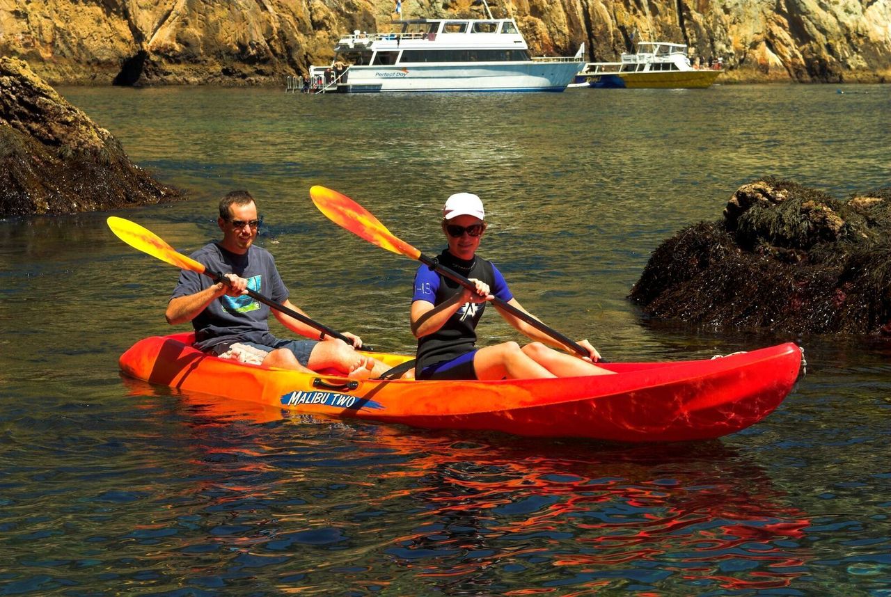 Two rowers in a sea kayak at Poor Knights Marine Reserve, New Zealand